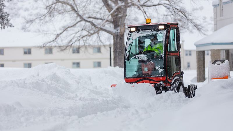 Räumfahrzeug auf einem Gehweg im Schnee